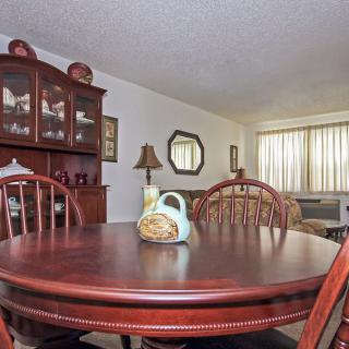 A cozy dining room with a wooden table and chairs, complemented by a cabinet and decorative items.