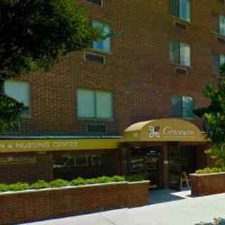 The entrance to a residential apartment building with a brick exterior and an awning.