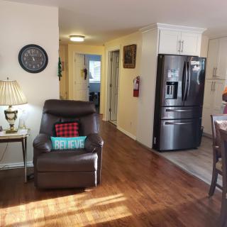 A cozy living area with a comfortable chair and adjacent kitchen space.