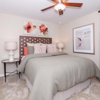 A modern bedroom with stylish decor, featuring a comfortable bed, lamps on side tables, and eye-catching artwork.