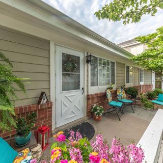 A cozy porch with colorful flowers and patio furniture.