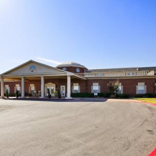 An exterior view of a building with a grand entrance and clear blue skies.