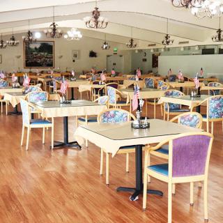 An empty dining room with neatly arranged tables and chairs.