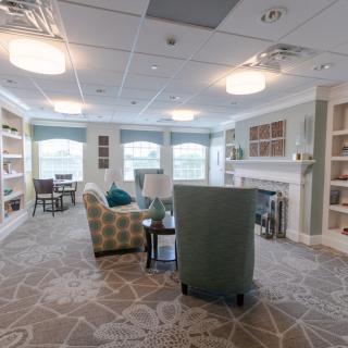 A cozy living room with comfortable seating, bookshelves, and soft lighting.