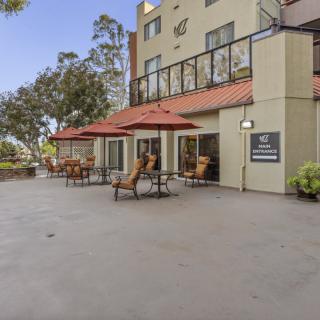 Outdoor seating area with umbrellas at a hotel patio.
