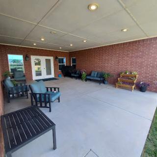 A spacious outdoor patio featuring comfortable seating arrangements, ideal for relaxation.