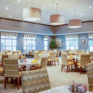 A spacious and well-lit dining area with multiple tables and chairs arranged neatly.