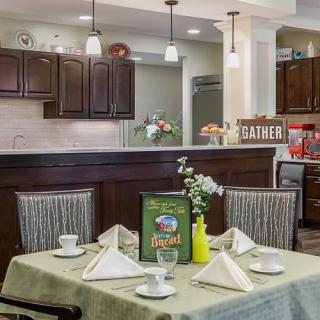 A cozy dining area with a neatly set table and an open view of the kitchen.