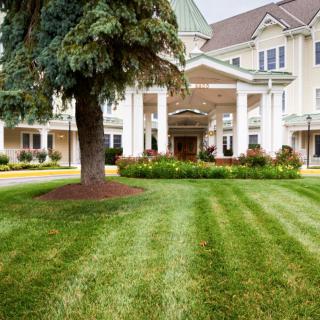 A well-maintained lawn leads to an elegant building with a grand entrance.