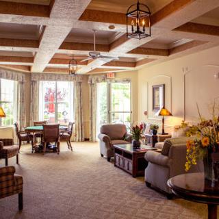 A cozy and inviting living room featuring elegant furniture, wooden beams, and ample natural light.