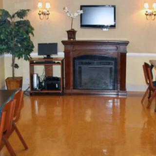 A cozy room featuring a fireplace, a television mounted above it, and a computer desk nearby.