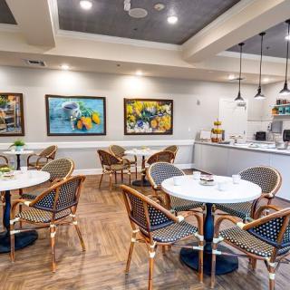 A cozy cafe interior with modern design, featuring tables and chairs alongside colorful artwork.