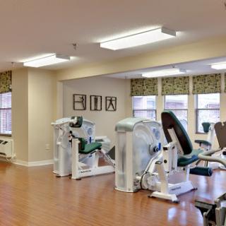 A modern fitness area equipped with exercise machines for strength training and rehabilitation.