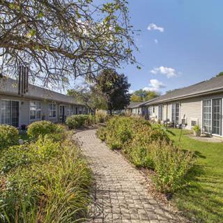 A peaceful garden with a stone pathway leading between buildings.