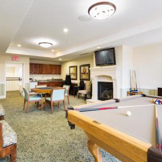 A cozy recreation room featuring a pool table, comfortable seating, and a dining area.