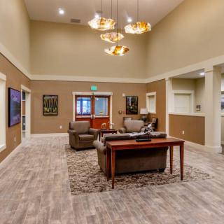 A spacious and modern living room featuring comfortable seating, elegant chandeliers, and tasteful decor.