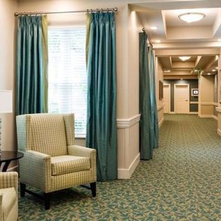 A well-lit hallway with comfortable seating and elegant curtains.