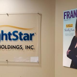 An office interior showcasing the BrightStar Holdings, Inc. logo and a promotional poster.