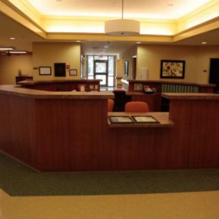 A well-lit reception area with a central desk and comfortable seating.
