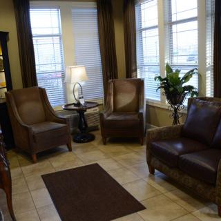 A cozy living room with leather chairs and warm lighting.