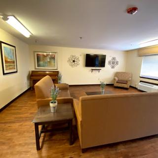 A cozy and inviting living room space featuring comfortable seating, a television, and decorative artwork.