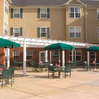 Outdoor seating area with umbrellas in front of a building.
