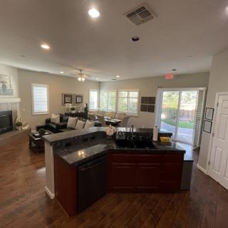 A modern open-plan living room and kitchen area with hardwood floors and contemporary furniture.
