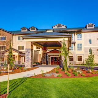 A modern hotel building with a well-maintained landscaped entrance.