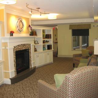 A cozy living room featuring a fireplace, comfortable seating, and built-in shelves.