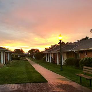 A serene sunset over a cozy pathway lined with charming buildings.