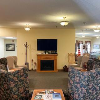 A cozy living room with a seating area facing a television and fireplace.