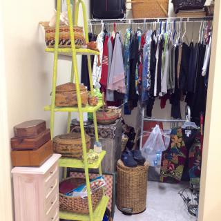 A well-organized closet with various clothing items hanging on racks and shelves filled with baskets and boxes.