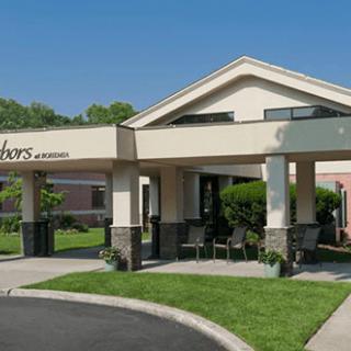 A building entrance with a covered canopy and landscaped surroundings.