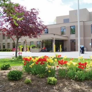 A picturesque view of a building surrounded by vibrant flowers and lush greenery.