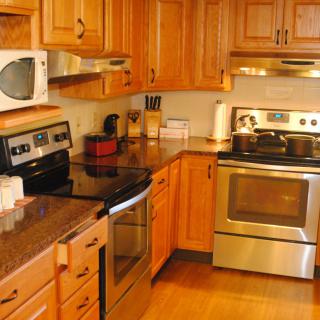 A modern kitchen with wooden cabinets and stainless steel appliances.