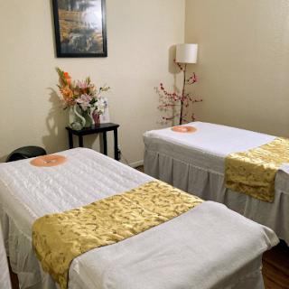 A serene massage room equipped with treatment beds, fostering a peaceful atmosphere for relaxation and wellness.