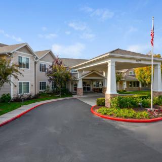A residential building with a covered entrance and a well-maintained driveway.