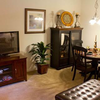 A cozy living room with a dining area, featuring warm lighting and elegant furniture.