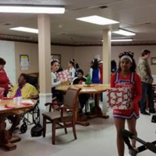 A group of people gathered indoors, participating in a holiday event with gifts.