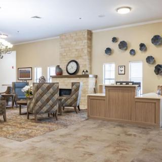 A cozy and elegantly decorated living room featuring comfortable seating, a fireplace, and artistic wall decor.