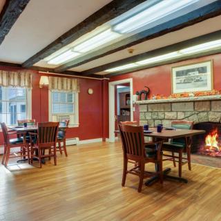 Cozy restaurant interior with a fireplace and wooden furnishings.