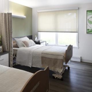A clean and well-lit hospital room with neatly arranged beds.