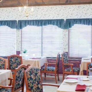 A cozy dining room with neatly arranged tables and floral patterned chairs.