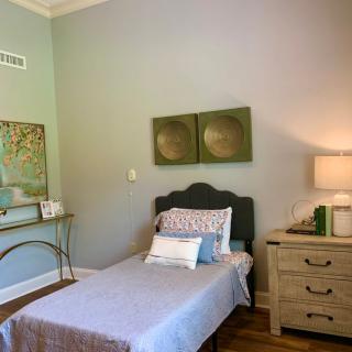 A cozy bedroom with a single bed, minimalist decor, and soft color tones.