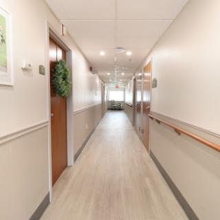 A well-lit and clean hallway with doors on either side.