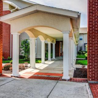 A covered walkway with columns leading to a building entrance.