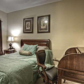 A cozy bedroom featuring a comfortable bed, elegant furniture, and warm lighting.
