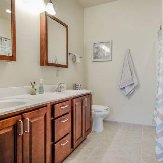 A well-lit bathroom featuring double sinks and wooden cabinetry.