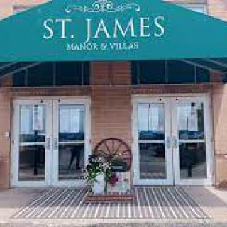 Entrance to St. James Manor & Villas with a welcoming floral display.