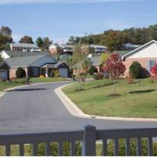 A peaceful suburban neighborhood with houses, trees, and a winding road.